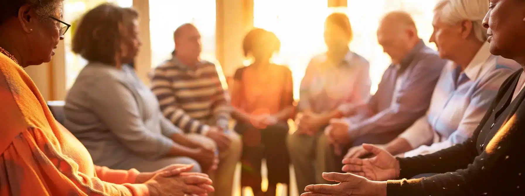 a group of diverse individuals holding hands in a circle, praying together in a sunlit room during a christian recovery meeting.