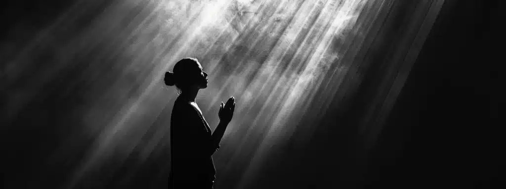 a person in silhouette standing in a beam of light, hands folded in prayer, surrounded by darkness symbolizing the power of faith in addiction recovery.