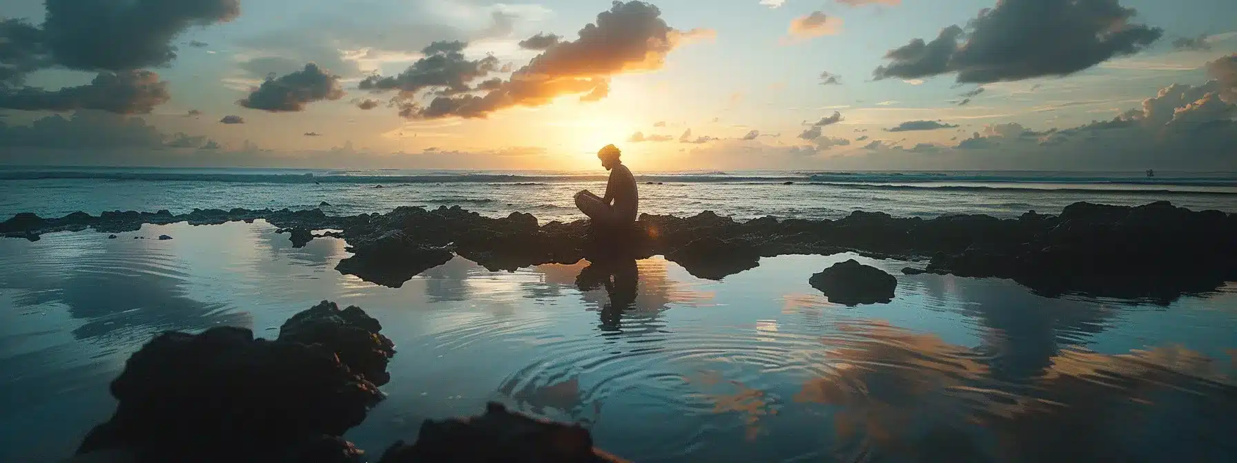 a serene sunset beach setting with a tranquil ocean view and a person in deep reflection.