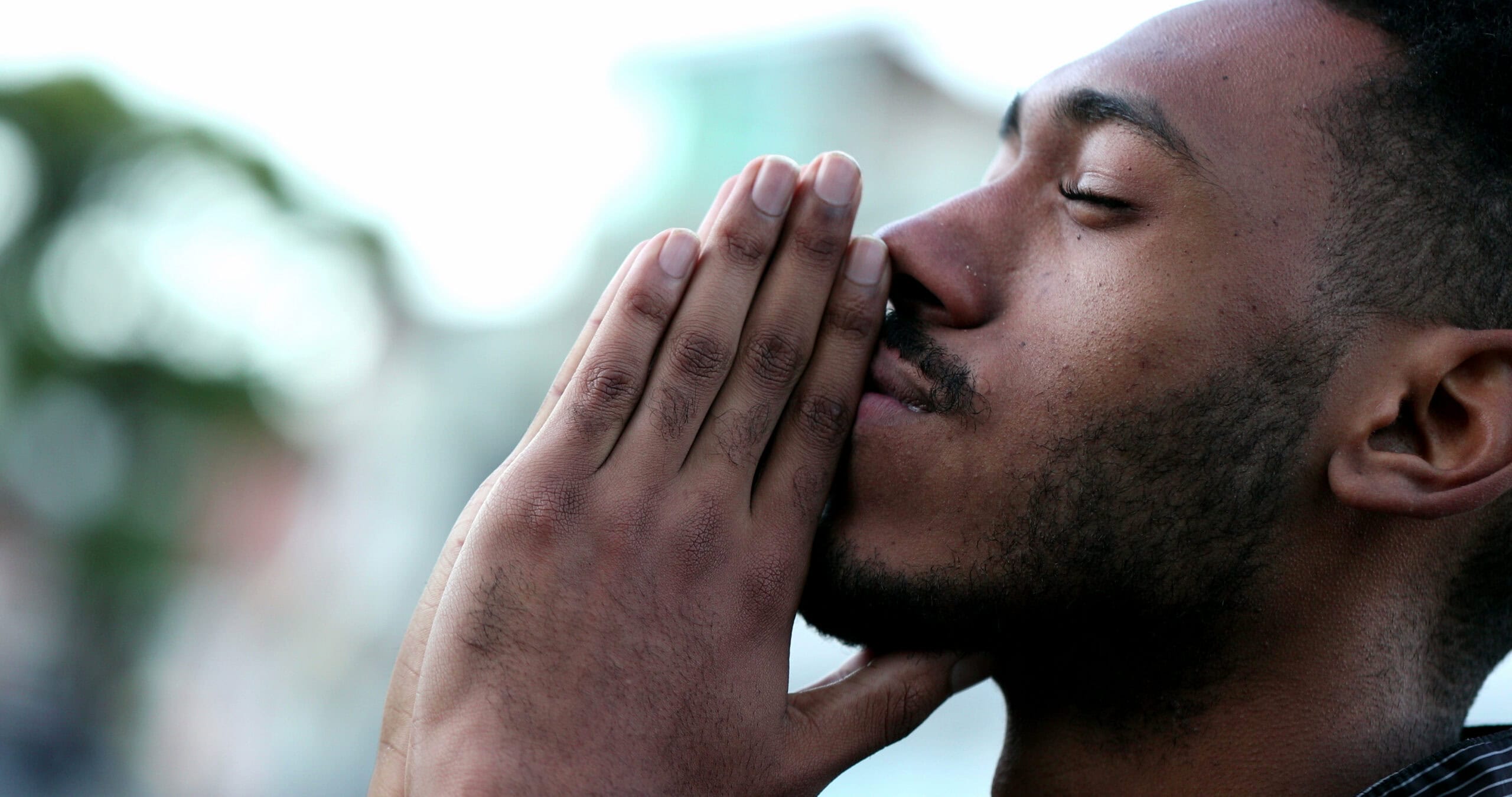 Young black man praying after asking How a Leap of Faith Might Feel.