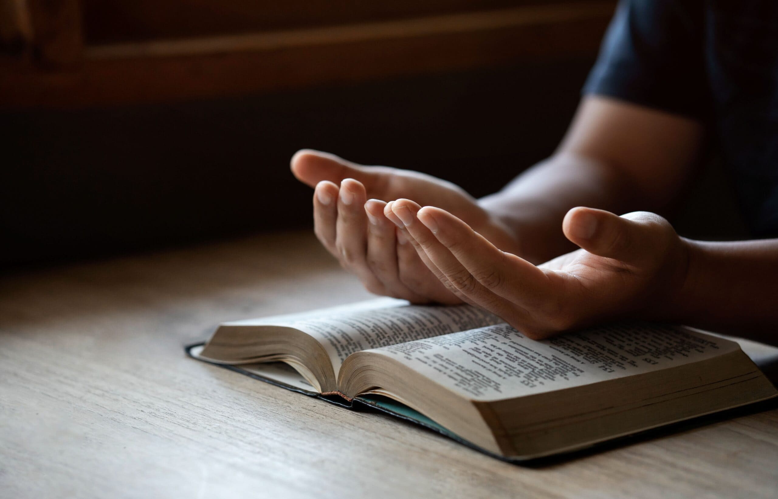 Man praying over Bible after reading a faithful friend bible verse​.
